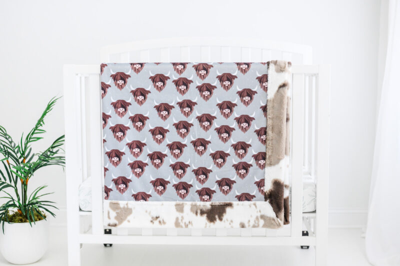 Sweet horn highland cow blanket hanging on crib