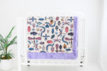 Colorful Doodle bug blanket hanging on crib