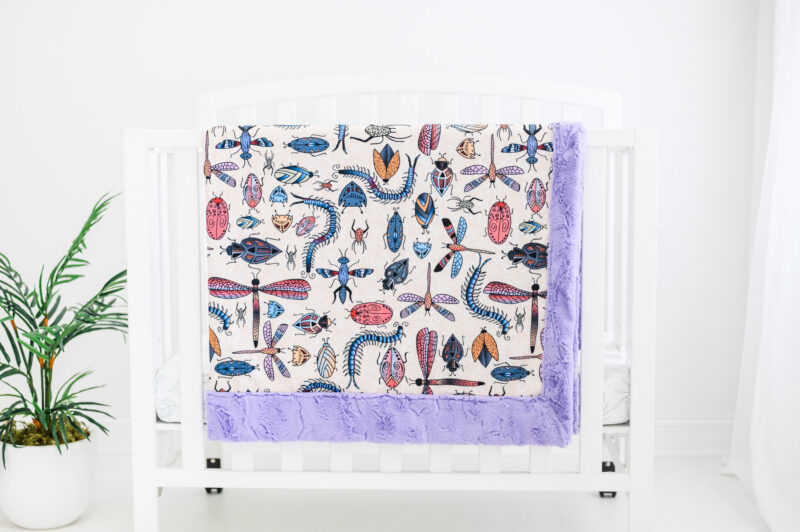 Colorful Doodle bug blanket hanging on crib