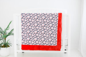 Baseball Grey blanket hanging on crib