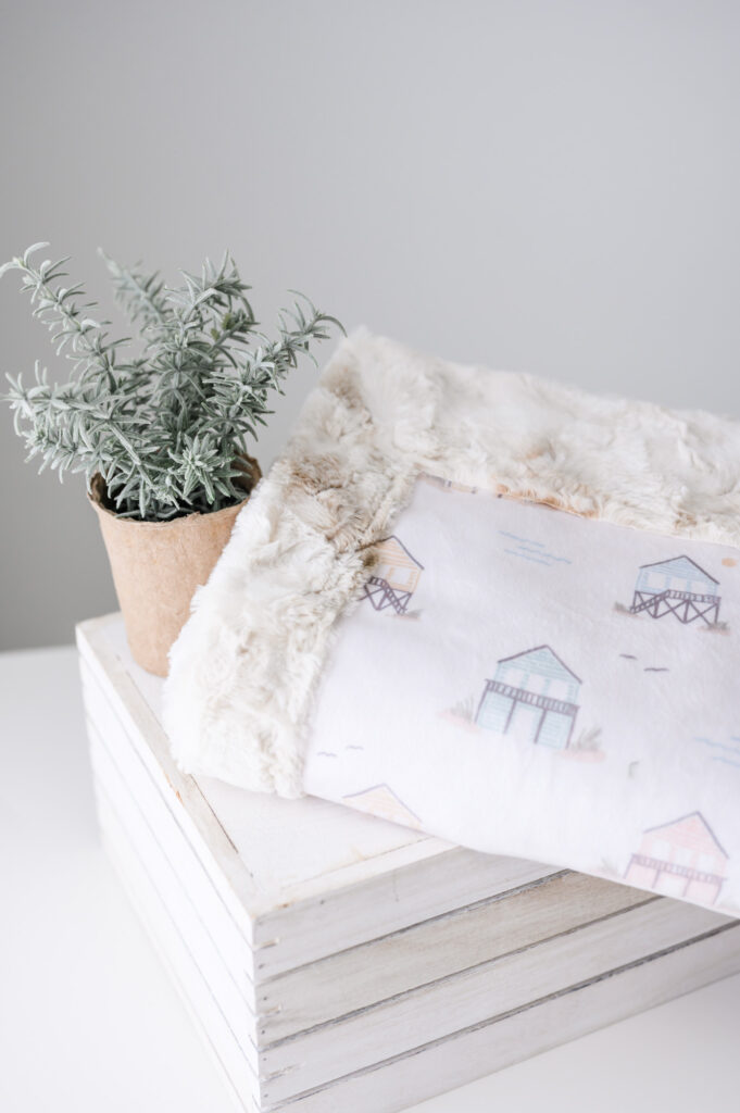 Childrens minky blanket on table featuring cottages